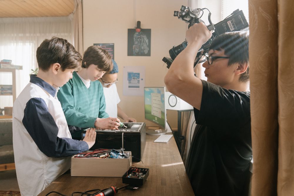 Des adolescents et un encadrant autour d'une caméra, en train de fabriquer un film